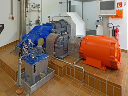 Die Durchströmturbine (blau) mit Generator (orange), dazwischen das Getriebe (grau) und Hydraulikaggregat (blau, im Vordergrund).